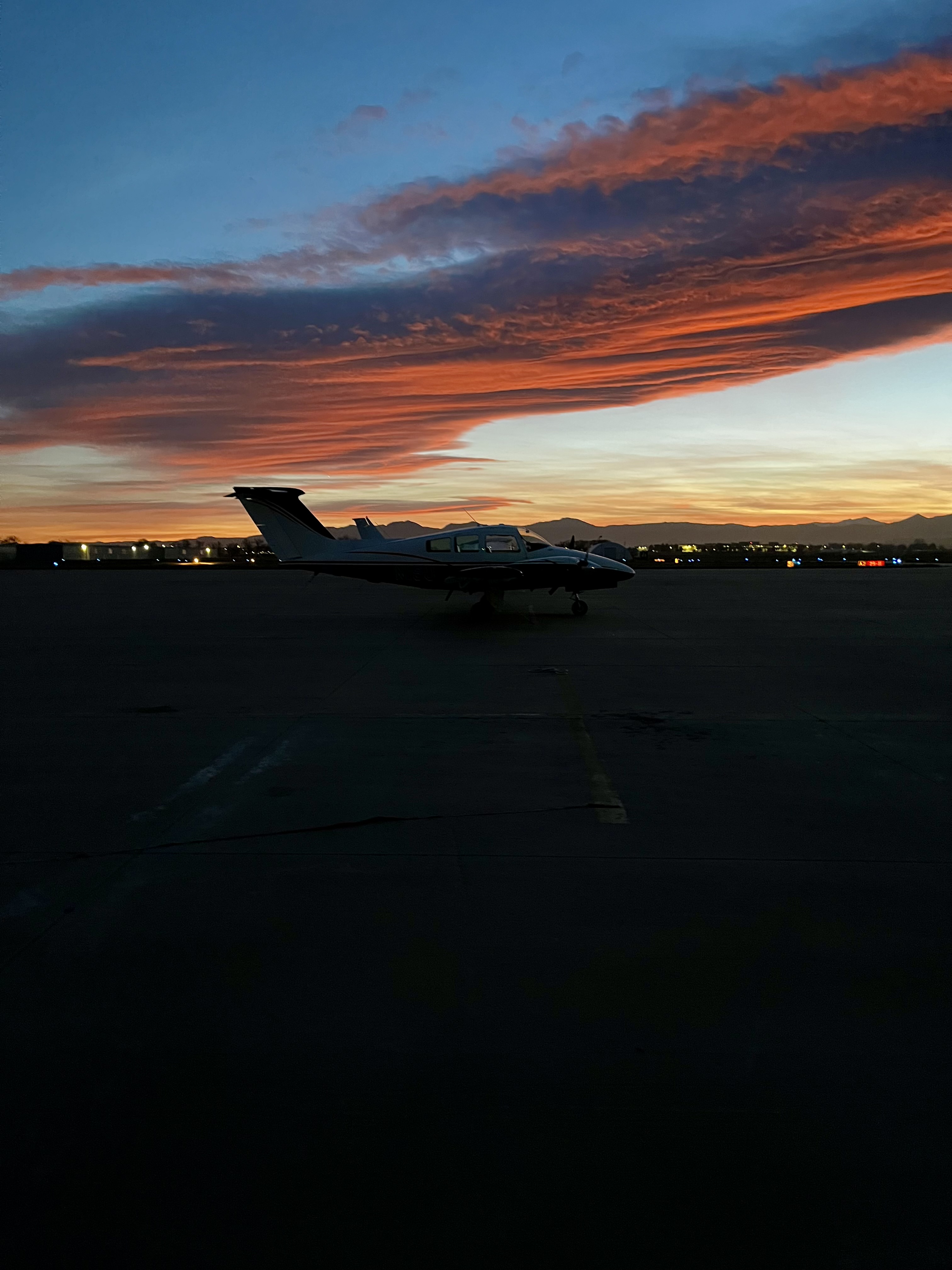 Piper aircraft parked under a sunset sky