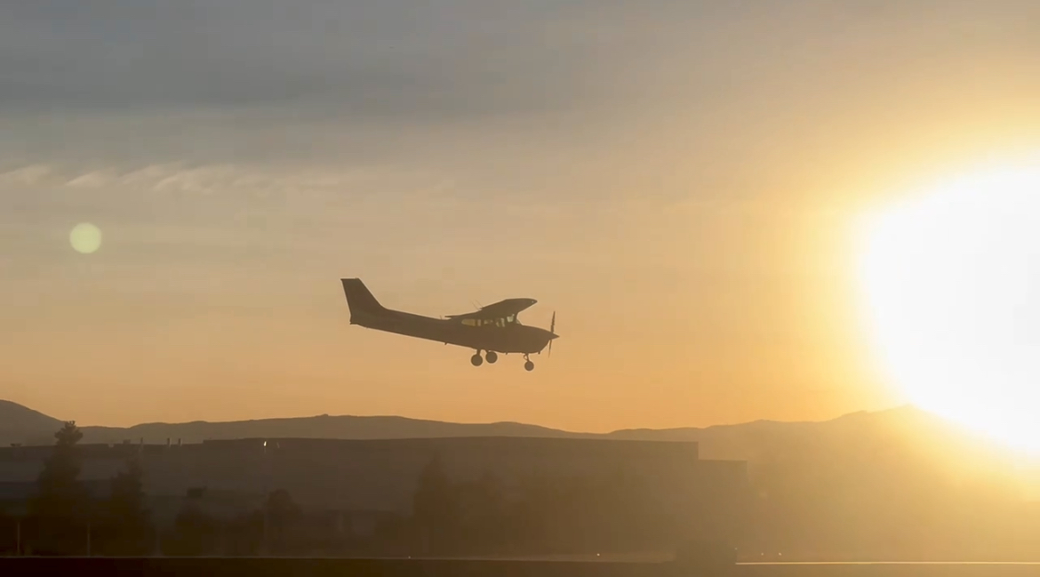 Small aircraft on approach at sunset