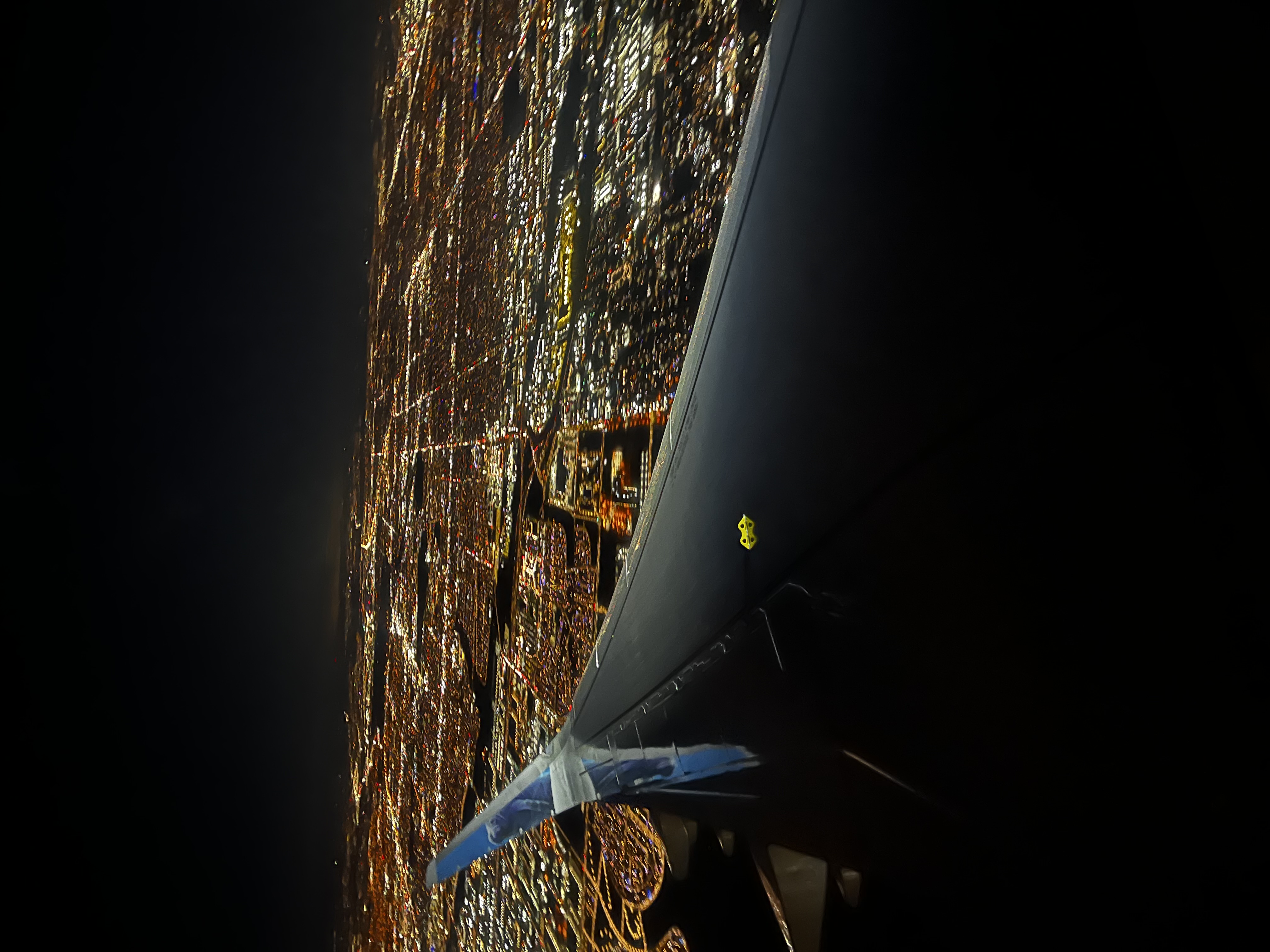 Aircraft wingtip view over a city at night